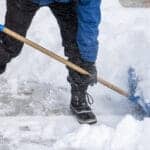 Part Man shoveling snow with blue plastic shovel