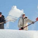 Man and woman shovel snow